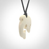 Hand carved bone dolphin pendant with black adjustable cord.